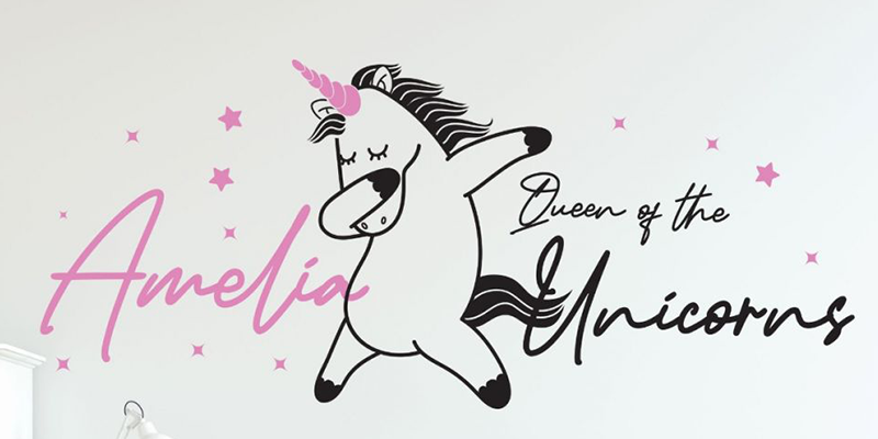 Custom wall decal with a dancing unicorn, pink stars, and personalized "Amelia, Queen of the Unicorns" text for kids' rooms.