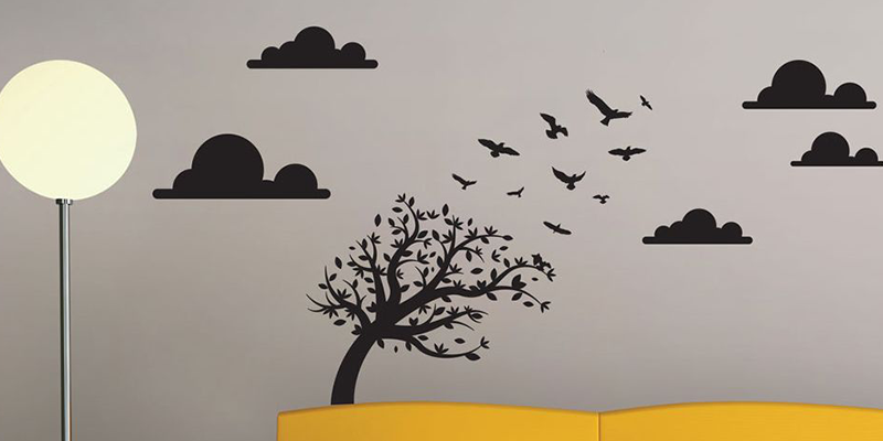 Nursery wall sticker featuring a tree with birds flying away, surrounded by clouds and a sun in a minimalist design.