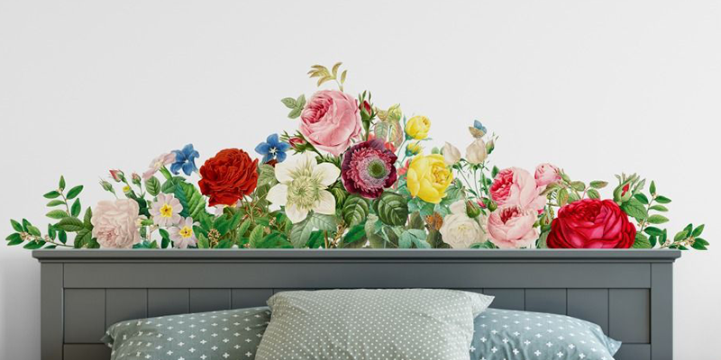 Wall stickers for bedroom featuring a vibrant floral arrangement with roses and greenery above a bed's headboard.
