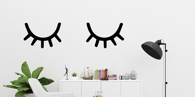 Simple black eyelash wall art above a modern decor setup, ideal to decorate a small house with minimalist style.