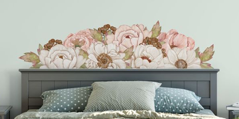 Beautiful wall decal featuring soft pink and white flowers with green leaves, designed as a headboard accent for a serene bedroom look.