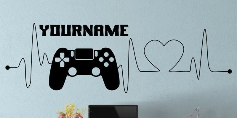 Black gamer wall decal for kids featuring a controller, heartbeat line, and customizable name. Great for gaming-themed rooms.