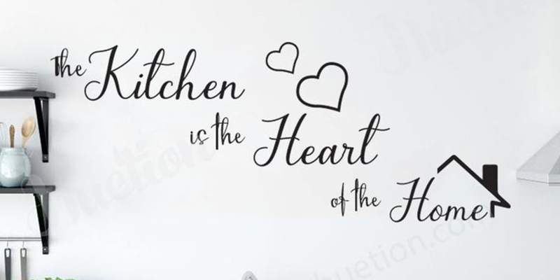 "The Kitchen is the Heart of the Home" wall quote sticker with heart shapes and house icon on a kitchen wall.