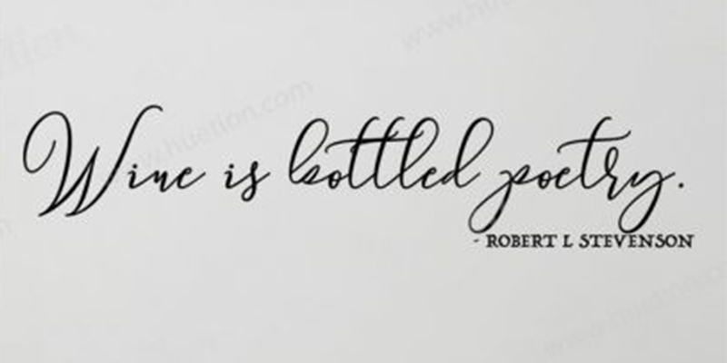Black script kitchen wall decal featuring the quote "Wine is bottled poetry" by Robert L. Stevenson.