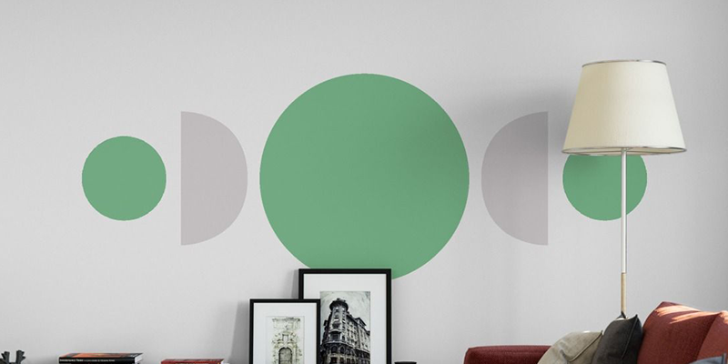Minimalist wall decal featuring green and gray geometric circles and semi-circles in a modern living room setting.