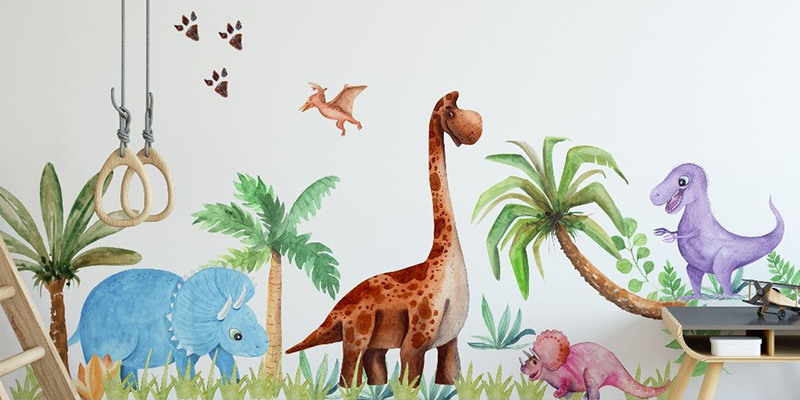Nursery wall sticker featuring colorful dinosaurs, palm trees, and a flying pterodactyl, creating a playful prehistoric scene.