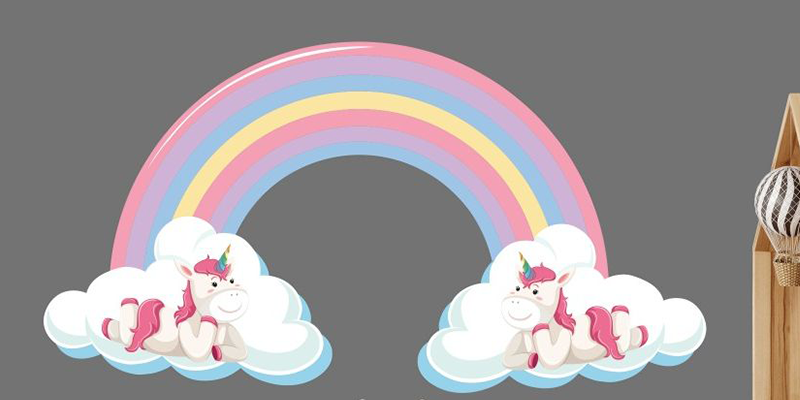 Rainbow wall sticker with two unicorns resting on clouds, adding a whimsical touch to children's room decor.