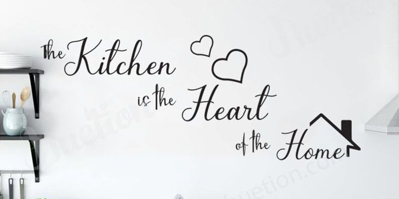 "The Kitchen is the Heart of the Home" wall quote sticker with heart shapes and house icon on a kitchen wall.