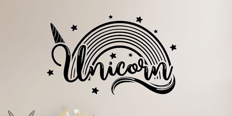 Stylish unicorn wall decal featuring a black rainbow, stars, and a unicorn horn, perfect for adding magic to any room.