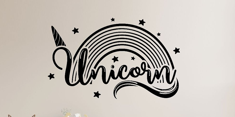 Stylish unicorn wall decal featuring a black rainbow, stars, and a unicorn horn, perfect for adding magic to any room.