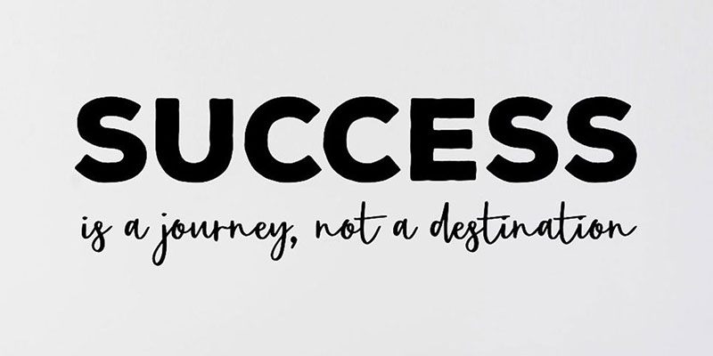 Black and white motivational wall art with the phrase "Success is a journey, not a destination" in bold and cursive fonts.
