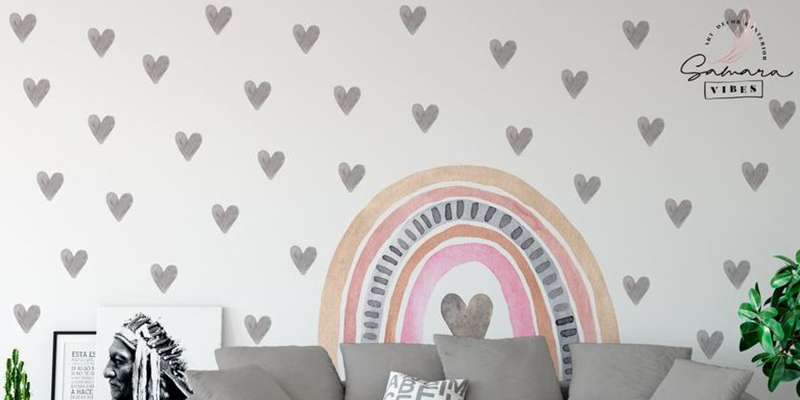Boho rainbow wall decals with neutral tones and heart patterns above a sofa, creating a cozy, modern room decor.