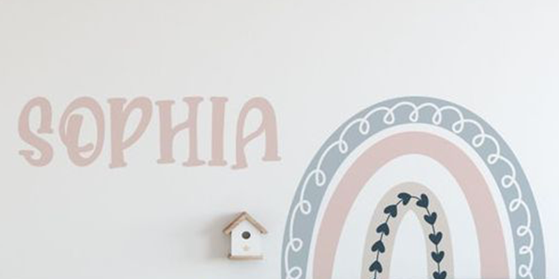 Pastel rainbow wall sticker with heart accents and "Sophia" text, decorated with balloons and a star ornament.
