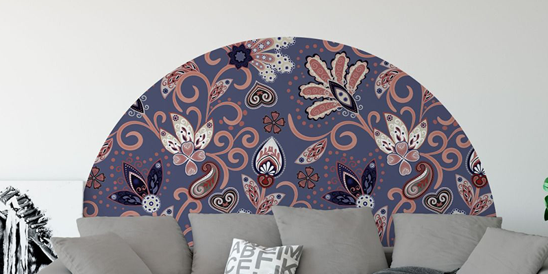 Semi-circle boho floral wall mural in blue and coral tones behind a neutral-colored couch, adding a decorative touch.