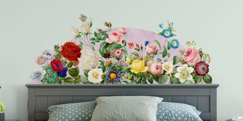Vibrant floral wall stickers for bedroom above a headboard, featuring colorful roses, daisies, and greenery in a garden design.