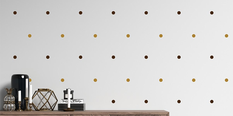 Boho-inspired wall stickers featuring brown and gold polka dots on a white wall above a minimalist shelf.