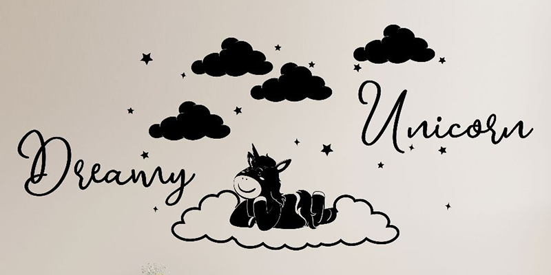 Nursery wall sticker featuring a unicorn resting on a cloud with stars, clouds, and the words "Dreamy Unicorn" in script.