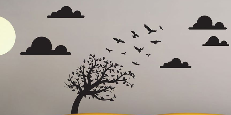 Nursery wall sticker featuring a tree with birds flying away, surrounded by clouds and a sun in a minimalist design.