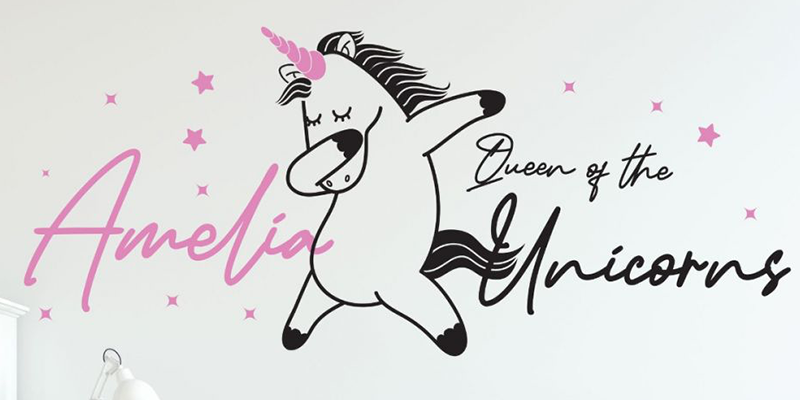 Custom wall decal with a dancing unicorn, pink stars, and personalized "Amelia, Queen of the Unicorns" text for kids' rooms.