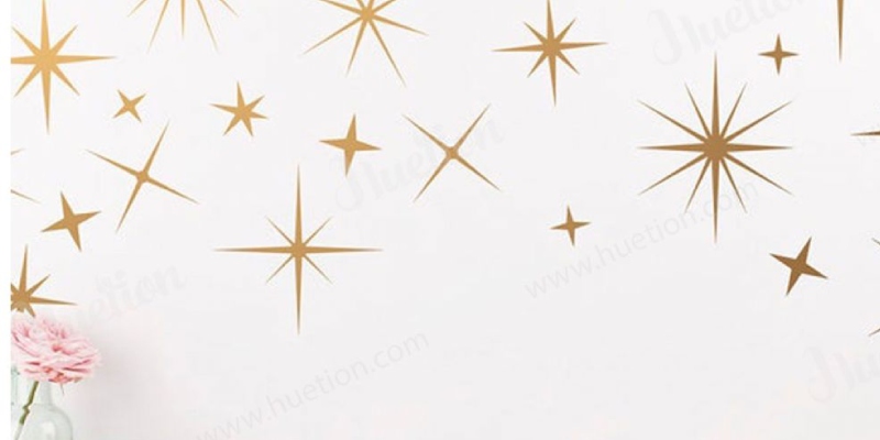 Gold star-shaped Boho wall stickers create a modern, celestial look on a white wall, adding a chic and trendy touch to the decor.