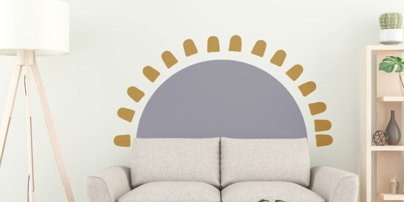 Wall decal featuring a gray half-circle with golden sunburst accents placed behind a light gray sofa.