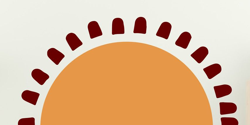 Boho wall sticker featuring a simple orange sun with dark red rays, perfect for creating a warm and earthy vibe.