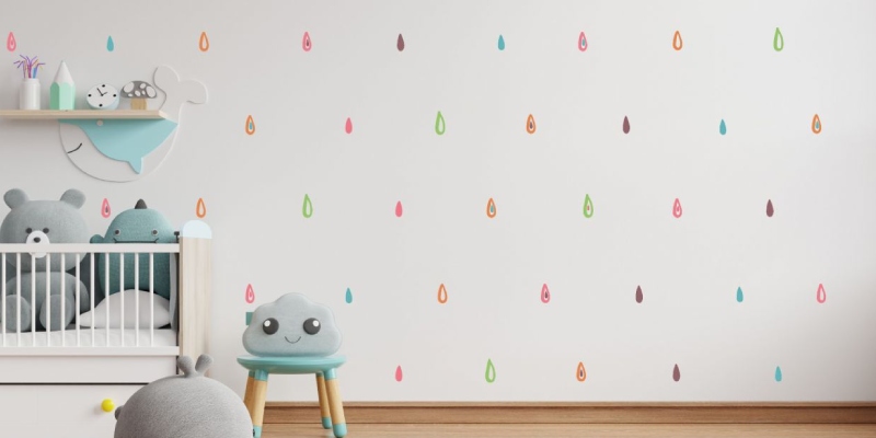 Multicolored teardrop-shaped rainbow wall decals on a white wall, adding a playful, vibrant touch to a nursery or kids' room.