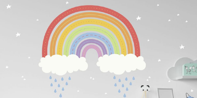 Large rainbow wall sticker with vibrant colors, white clouds, and raindrops, placed on a light gray wall with star details.